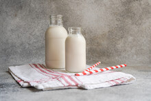 Raw Cow Milk In Vintage Bottles On Rustic Napkin And Drinking Straws