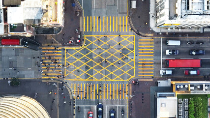 Wall Mural - Car traffic transport on road, pedestrian people walk cross zebra crossing, crossroad junction in Mong Kok, Hong Kong downtown. Drone aerial top view. Asian lifestyle, Asia transportation city life