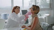 Dermatologist touching woman face examining skin in modern cosmetology clinic.