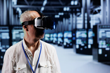 Aged computer scientist immersed in virtual reality at data center, doing hardware maintenance. Worker using VR headset to optimize server rigs system performance, harnessing cutting edge technology