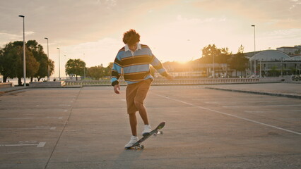 Stylish guy jumping skateboard sunset background. Millennial person riding skate