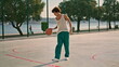 © stockbusters - Sportive teen training playground alone. Involved student enjoying basketball