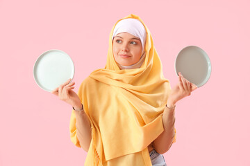 Canvas Print - Beautiful Arabian woman with empty plates on pink background