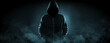 © New Africa - Anonymous man in hood surrounded by smoke on black background. Banner design