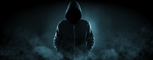 Anonymous man in hood surrounded by smoke on black background. Banner design