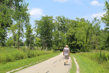 Old Man With Floppy Hat Walking On The North Branch Trail In Morton Grove, Illinois