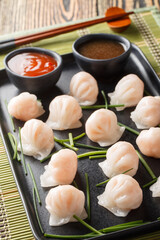 Traditional Asian Prawn or shrimp dumplings hakau, ha kauw or har gow served with sauce on the table. Vertical