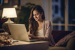 © HiroSund - Woman using a laptop in the living room
