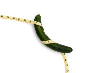 Measuring tape around cucumber on white background.