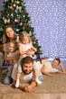 © Evgenia Tiplyashina - christmas family near christmas tree