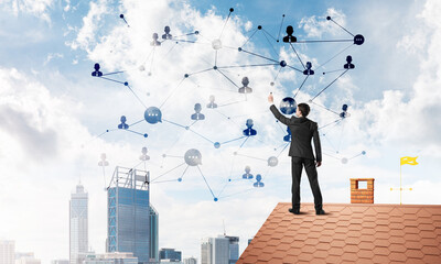 Wall Mural - businessman on house roof presenting networking and connection concept. mixed media