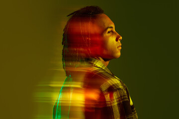 Portrait of young african man posing against gradient green background in neon light. Mixed light effect. Freedom. Concept of art, fashion, modern style, cyberpunk, futurism, ad