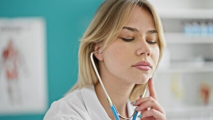 Poster - Young blonde woman doctor examining using stethoscope at clinic