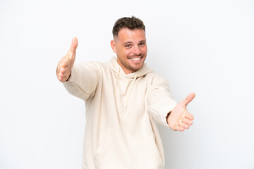 Wall Mural - Young caucasian handsome man isolated on white background presenting and inviting to come with hand