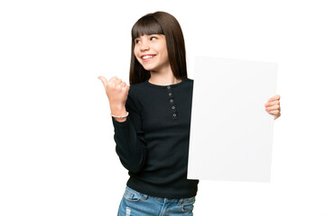 Wall Mural - Little girl over isolated chroma key background holding an empty placard and pointing side