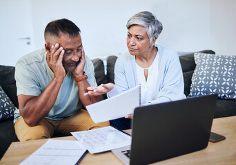 Canvas Print - Frustrated senior couple, documents and laptop in debt, financial crisis or struggle on sofa at home. Upset elderly man and woman in disagreement, argument or fight with finance, bills or expenses