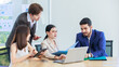 © Bangkok Click Studio - Asian Indian multinational professional successful bearded male businessman explaining discussing brainstorming with female businesswomen colleagues in formal business suit in office meeting room