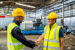 © BESTIMAGE - greeting by handshake touch fist and elbow of two engineer supervisor partnership in old factory. foreman greeting friend for good friendship colleague laborer in teamwork factory.