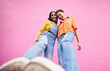 © Davids C/peopleimages.com - Selfie, fashion and portrait of friends on pink background in city with trendy clothes, stylish and cool outfit. Happy, creative and below of female people for freedom on holiday, vacation or weekend
