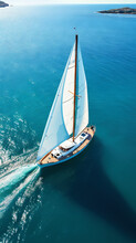 Aerial Image Of Beautiful Sailboat Cruising In Blue Open Ocean. Luxury White Yacht. Generative AI