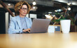 © Jacob Lund - Business woman working on a laptop in a coworking office