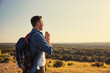 © baranq - Adult man praying meditating while hiking during sunset
