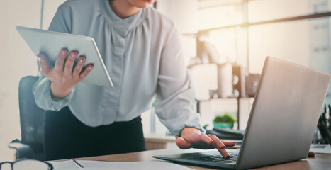 Tablet, laptop and business woman hands at web analyst company with typing. Technology, female person and online professional working in a office with computer and digital data research for project