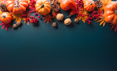 Wall Mural - Thanksgiving and Autumn decoration concept made from autumn leaves and pumpkin on dark background. Flat lay, top view with copy space.