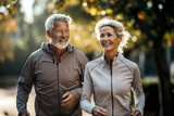 Senior couple jogging in the park. They are looking at camera and smiling.