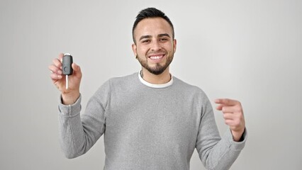 Poster - Hispanic man smiling confident pointing to key of new car over isolated white background