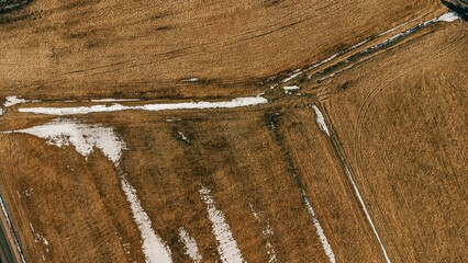 Canvas Print - aerial view of tractor moving on farm land with a blue sky in background