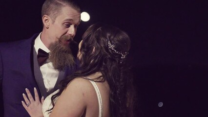 Wall Mural - Caucasian bearded groom and bride kissing during the wedding night outdoors, slow motion