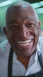 © Marco - Portrait of a happy Elderly African American Man with Gray Hair and Wrinkles, Wearing Black Apron, smiling at camera with joyful expression. Charismatic and friendly employee person
