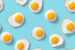 © dinastya - Fried eggs on blue pastel background seamless pattern, top view creative tile ornament, fried egg repeat texture for wrapping paper or textile print. 3d render cartoon illustration style.