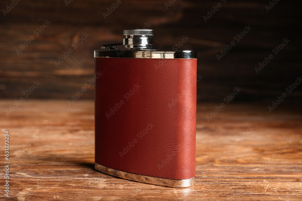 New hip flask on wooden background