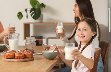 Sticker - Little girl eating corn balls with milk in kitchen