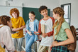 © LIGHTFIELD STUDIOS - happy teenagers talking in classroom, back to school, classmates communicating during school break