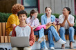 © LIGHTFIELD STUDIOS - back to school, happy teen boy looking at camera, holding laptop, diversity, teacher and students