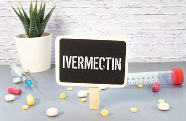 Wall Mural - Doctor holding a card with text TREATMENT IS IVERMECTIN, medical concept.