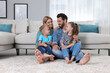 © New Africa - Happy family spending time together on soft carpet at home