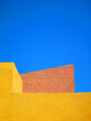Gelbes und rötliches Hausdach die in den blauen Himmel emporragen