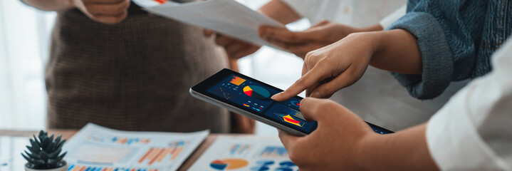Poster - Analyst team utilizing BI Fintech to analyze financial report with tablet over paper on table and analyzing BI power dashboard display on tablet screen for business insight. Panorama shot. Scrutinize