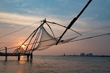 Sunset Over Chinese Fishing Net At Sunrise In Cochin Fort Kochi, Kerala, India