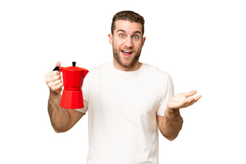 Wall Mural - Young handsome blonde man holding coffee pot over isolated chroma key background with shocked facial expression