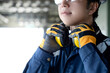 © Summer Paradive - Asian man construction worker wearing uniform suit, safety helmet, goggles and protective gloves holding yellow ear muffs or ear defenders on his neck at construction site
