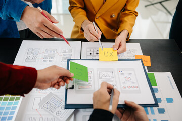 Wall Mural - close up view of ui developer team brainstorming on their project with laptop, smartphone and digita