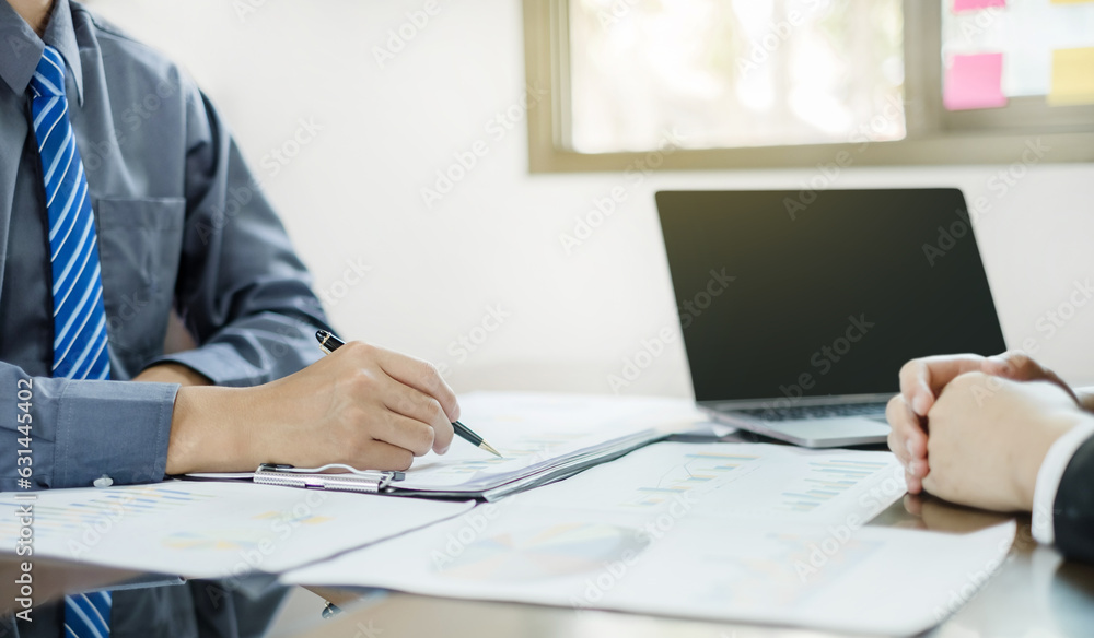 Two business leaders talk about charts, financial graphs showing ...