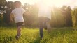 © maxximmm - children run in the park. a boy and a girl holding hands run through the grass in the summer at sunset in the park. happy family kid dream concept. children run at sunset in summer hold hands sun