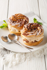 Wall Mural - Paris-Brest is a French dessert made of choux pastry and a praline flavoured cream closeup on a plate on the wooden table. Vertical