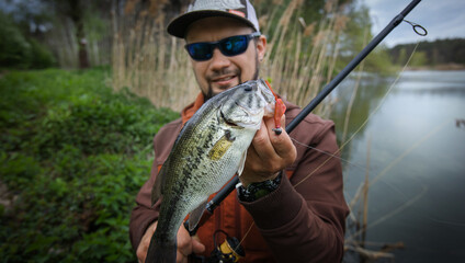 Fishing background. Young Happy angler with fishing trophy.